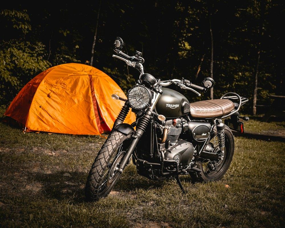 Scrambler parked beside an orange tent
