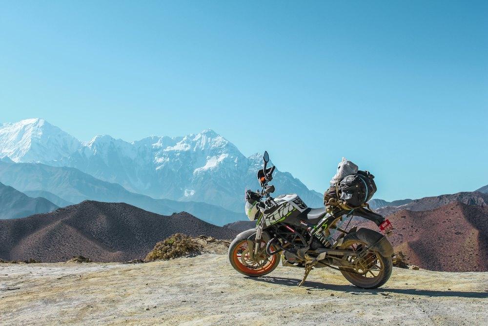 Loaded motorcycle with snow-capped mountains behind